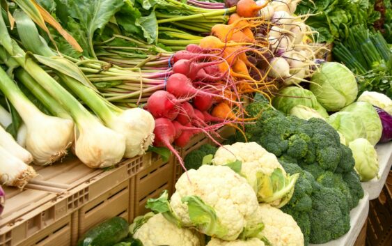 green and red vegetable on brown wooden table